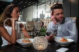 Man ignoring woman while dining