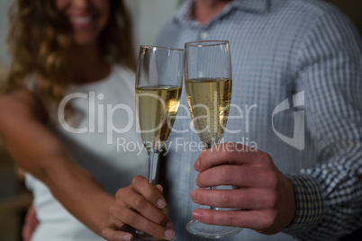 Mid section of couple holding champagne glass