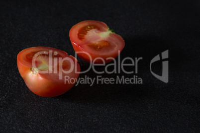 Halved tomato on black background