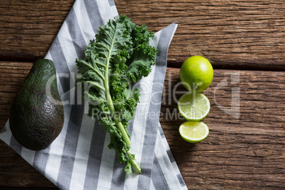 Mustard greens, avocado and lemon on wooden table