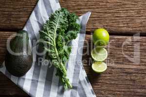 Mustard greens, avocado and lemon on wooden table