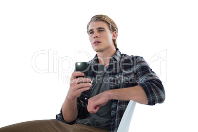 Businessman photographing while sitting on chair