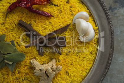 Rice with bay leaf, garlic, dried red chili pepper, ginger and cinnamon in plate