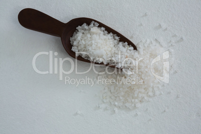 Sea salt scattered out of wooden scoop