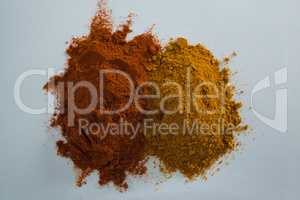 Cinnamon powder and curry powder on white background