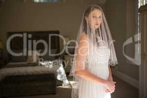 Portrait of bride in wedding dress at home