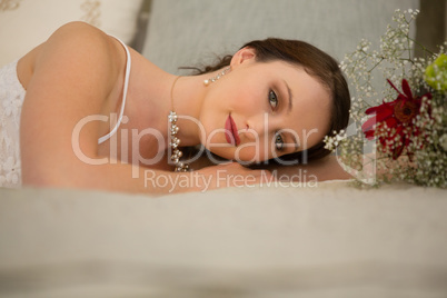 Portrait of beautiful bride relaxing on bed at home