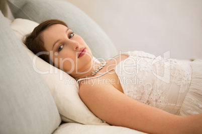 Portrait of beautiful bride relaxing on bed