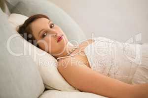 Portrait of beautiful bride relaxing on bed