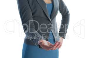 Mid section of businesswoman with hand on hip gesturing against white background