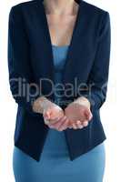 Mid section of businesswoman standing with hands cupped