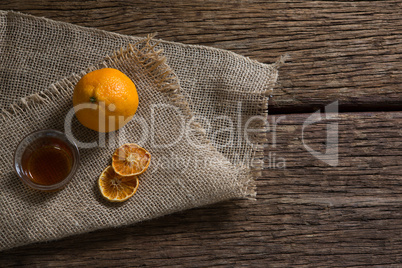 Bowl of orange tea with orange on textile