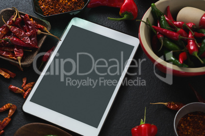 Various spices with digital tablet on black background