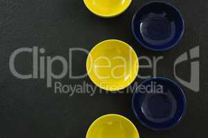 Yellow and blue plastic bowl on black background