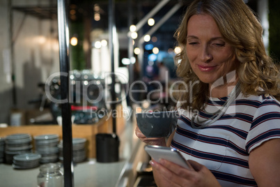 Beautiful woman using mobile phone mobile phone while having coffee
