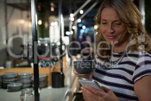 Beautiful woman using mobile phone mobile phone while having coffee