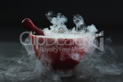 Dry ice smoke in bowl on black background