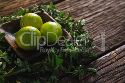 Lime fruits in a bowl with herbs