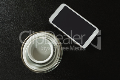 Empty bowls with mobile phone on black background