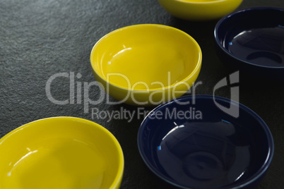 Yellow and blue plastic bowl on black background