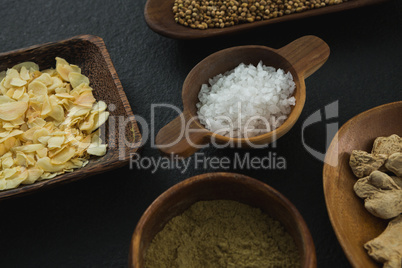 Various spices in bowl on black background