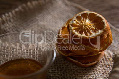 Bowl of orange tea with dried orange on textile