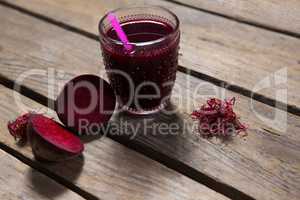 Beetroot juice and slice of beetroot on wooden table