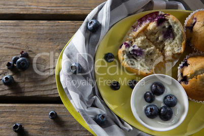 Blueberries with yogurt and muffins on plate