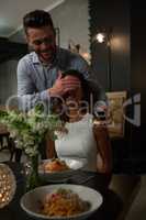 Man covering woman eye while dining