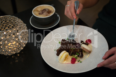 Woman having dessert and coffee at table