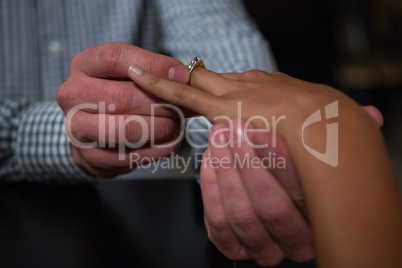 Man putting ring in woman finger