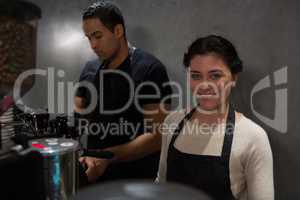 Portrait of waitress standing at counter with her colleague