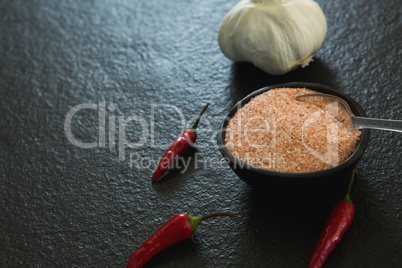 Garlic, red chili pepper and salt on black background