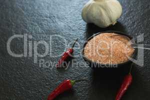Garlic, red chili pepper and salt on black background