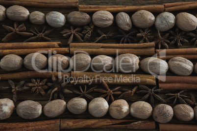 Nutmeg, star anise and cinnamon sticks arranged on wooden table
