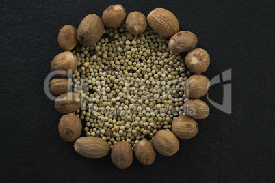 White peppers surrounded with nutmegs