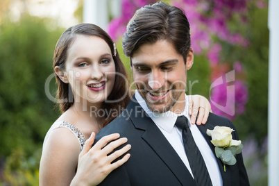 Beautiful bride with bridegroom standing in park