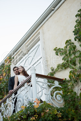 Low angle view of couple embracing while standing in balcony