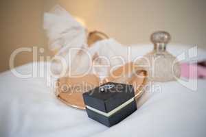 High angle close-up of sandals with perfume sprayer and wedding ring