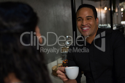 Happy man interacting with woman while having coffee