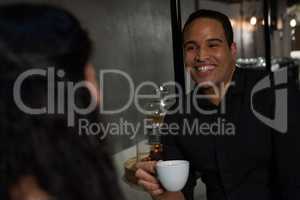 Happy man interacting with woman while having coffee