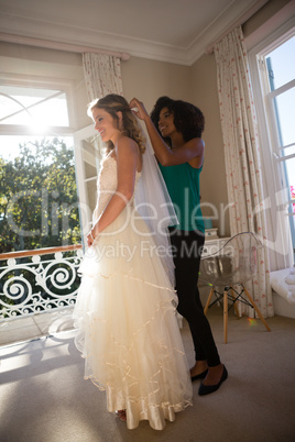 Beautician adjusting veil on bride hair