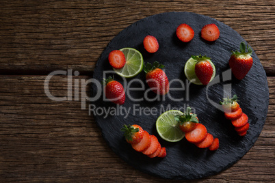 Sliced strawberries and lemon on round tray