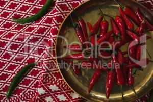 Red chilies in plate on table cloth