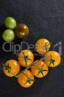 Yellow tomatoes on black background