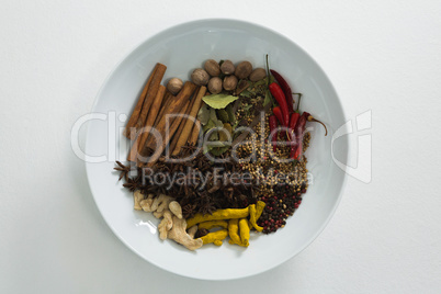 Various spices in plate on white background