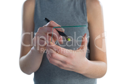 Mid section of businesswoman writing on transparent glass interface