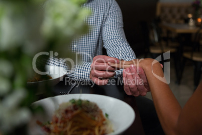 Mid section of man putting ring in woman finger