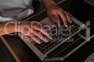 Mid section of man using laptop at table