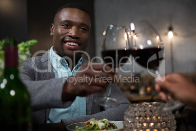 Man toasting red wine while dining
